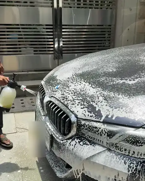 Thick foam sprayed over the front of a black BMW