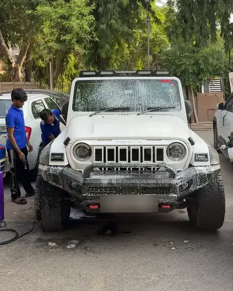 Two Washing Daddy washers working on a foamed white Mahindra Thar