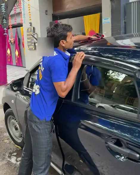 Washer drying the roof of a car with a microfibre cloth